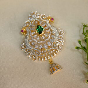 A teardrop-shaped pendant with a gold-plated frame, adorned with sparkling cubic zirconia stones and a central green gemstone.