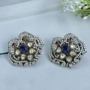 The image shows a pair of stunning earrings. They are made of silver and adorned with a mix of white and blue stones. The design is intricate and detailed, with a floral motif. The earrings look like they would be perfect for a special occasion.