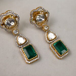 The image showcases a pair of elegant earrings. Each earring features a central rectangular emerald-cut moissanite, surrounded by a halo of smaller, sparkling white moissanites. Below the central stone, a pear-shaped moissanite dangles, adding a touch of movement and sophistication. The earrings appear to be crafted in gold, with intricate details surrounding the gemstones