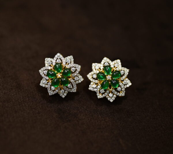 This image showcases a pair of elegant stud earrings featuring a floral design. The earrings are crafted with a combination of sparkling cubic zirconia (CZ) stones and vibrant green gemstones, creating a beautiful contrast. Floral