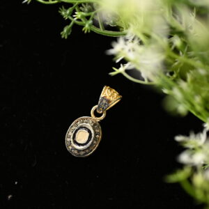 The image shows a beautiful oval-shaped diamond pendant. The central diamond is surrounded by a delicate halo of smaller diamonds, creating a sparkling and eye-catching design. The pendant appears to be made of gold or silver, and it hangs from a simple bail. The overall impression is one of elegance and sophistication.