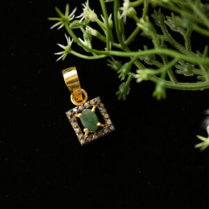The image showcases a delicate and elegant pendant featuring a square design with a central green stone and a halo of diamonds. It appears to be crafted with attention to detail and would make a beautiful addition to any jewelry collection.