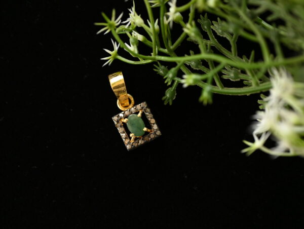 The image evokes a sense of elegance and understated luxury. The combination of the green gemstone and the sparkling diamonds creates a visually appealing contrast. The dark background further highlights the pendant's intricate details.