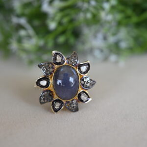 The image shows a beautiful ring with a large, oval-shaped tanzanite gemstone as the centerpiece. The tanzanite is a deep blue color, showcasing its natural beauty.