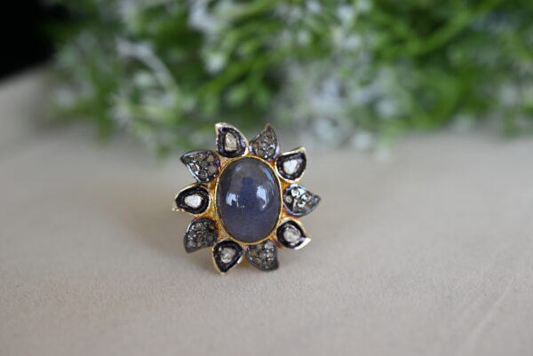 The image shows a beautiful ring with a large, oval-shaped tanzanite gemstone as the centerpiece. The tanzanite is a deep blue color, showcasing its natural beauty.