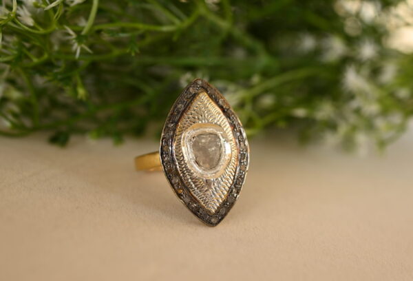 The image showcases a delicate and elegant sterling silver ring adorned with a rose-cut diamond. The ring appears to be handcrafted with attention to detail.
