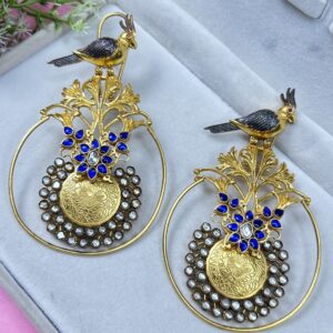 The image showcases a pair of exquisite fusion earrings. They appear to be handcrafted with a blend of traditional Indian motifs and contemporary design elements. Shape: The earrings have a circular base with intricate silver-toned detailing.