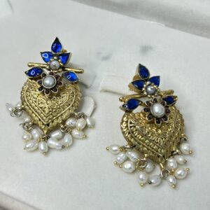 Intricate Detailing: The heart is covered in intricate gold-toned filigree work, creating a delicate and textured surface. Gemstones: Several small, round blue gemstones are set within the filigree work, adding a pop of color. Pearls: Clusters of small, white pearls hang below the heart, creating a dangling effect.