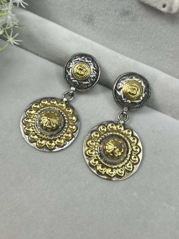 The image shows a pair of delicate earrings. The earrings are made with a combination of materials, featuring:
