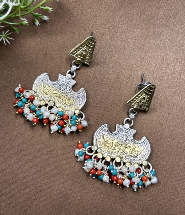 The image provides a clear view of the earrings from multiple angles, highlighting the intricate details and design elements. The background of the image is a neutral color, which helps to draw attention to the earrings and their intricate details.