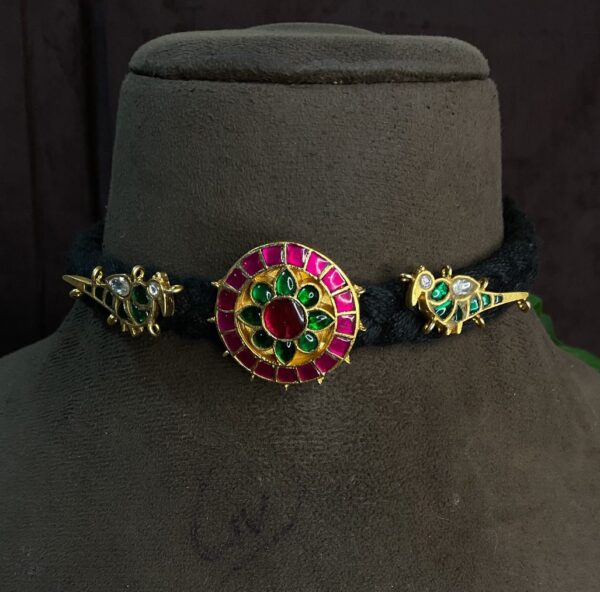 The image showcases a beautiful traditional Indian necklace, likely crafted using the kundan technique. It has a rich, vibrant look with a mix of colors and intricate details.