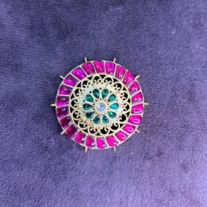 The image showcases a captivating Kundan pendant set against a dark, velvety background. The quality of the image is good, allowing for a clear view of the pendant's details.