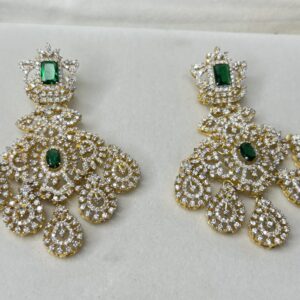The image shows a pair of elegant earrings with a unique design. They appear to be made of silver and feature a central drop with a delicate filigree pattern. The earrings have a vintage or antique aesthetic, possibly inspired by Victorian or Edwardian jewelry.