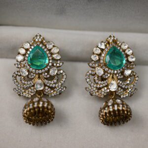 The image features a pair of stunning green moissanite earrings. The earrings are crafted in silver and feature a teardrop-shaped design with intricate floral detailing. The teardrop drops are adorned with multiple facets that reflect light beautifully, creating a dazzling sparkle.