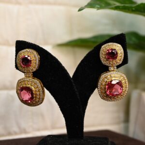 The image shows a pair of elegant dangle earrings. The earrings are made of silver and feature two large, square-cut pink gemstones. These gemstones are likely rubellites, a type of tourmaline known for its vibrant pink color.