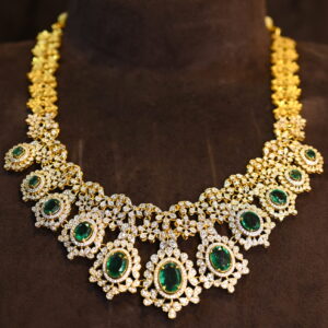 The image showcases a beautiful necklace crafted with moissanites. The necklace features a central cluster of emerald-cut moissanites, surrounded by a halo of smaller, pear-shaped moissanites. Delicate chains of teardrop-shaped moissanites cascade downwards from the central cluster, creating a mesmerizing waterfall effect. The overall design is reminiscent of traditional Indian jewelry with a contemporary touch. 925 Silver