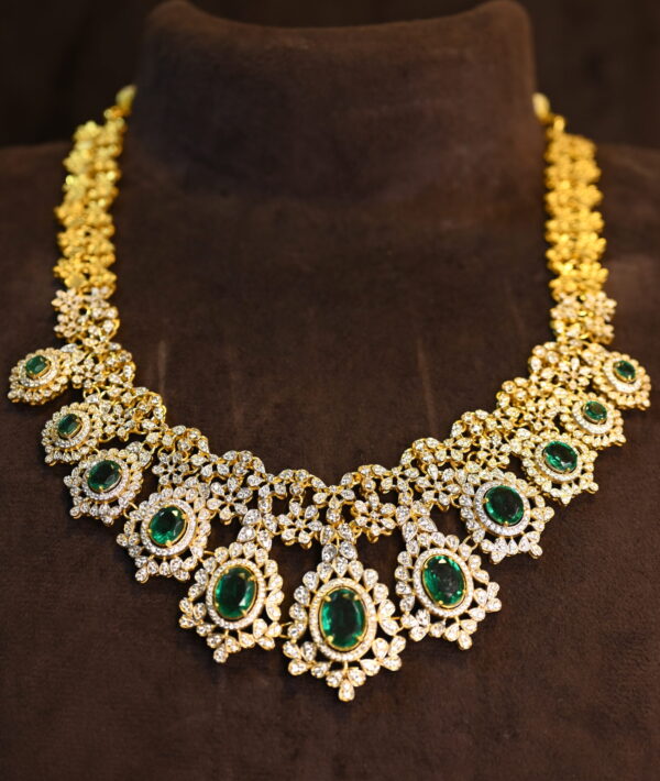 The image showcases a beautiful necklace crafted with moissanites. The necklace features a central cluster of emerald-cut moissanites, surrounded by a halo of smaller, pear-shaped moissanites. Delicate chains of teardrop-shaped moissanites cascade downwards from the central cluster, creating a mesmerizing waterfall effect. The overall design is reminiscent of traditional Indian jewelry with a contemporary touch. 925 Silver