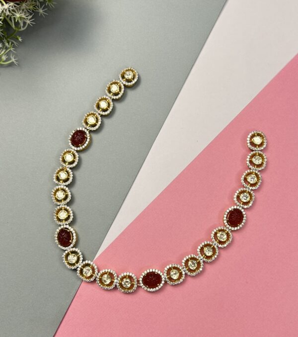 The image shows a necklace with alternating round moissanites and oval-shaped red gemstones. The necklace is laid out on a multi-colored background, with a red rosebud in the top left corner. 925 Silver