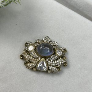 The image shows a beautiful pendant featuring a large, oval-shaped moissanite gemstone. The pendant is crafted with intricate detailing, showcasing a cluster of smaller moissanites surrounding the central stone.