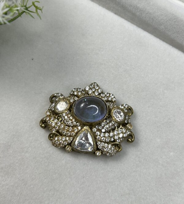 The image shows a beautiful pendant featuring a large, oval-shaped moissanite gemstone. The pendant is crafted with intricate detailing, showcasing a cluster of smaller moissanites surrounding the central stone.