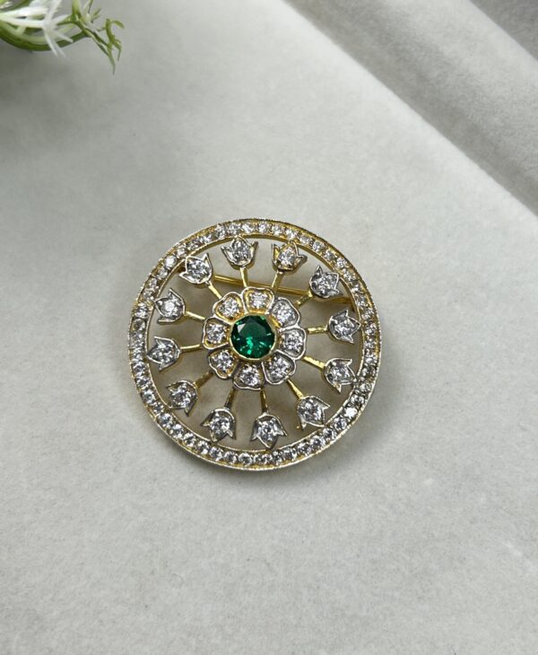 The image shows a close-up of an elegant gold pendant. The pendant has an oval shape and features a central, round-cut moissanite stone. Surrounding the center stone is a halo of smaller moissanites, creating a dazzling display of sparkle. The pendant's design is further enhanced by intricate filigree work and a delicate border of smaller stones.
