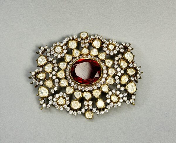 "A rectangular moissanite pendant with a large ruby in the center and surrounded by smaller diamonds." "A close-up of a vintage-style pendant with a ruby and diamond embellishments."