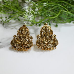 Pair of 925 silver temple earrings featuring a seated deity flanked by peacocks, adorned with ruby-green spinels and antique gold polish."​ This description is concise, informative, and adheres to best practices for accessibility and SEO. If you have multiple images of the earrings from different angles or contexts, consider specifying the view in each alt text, such as "Side view of 925 silver temple earring with deity and peacock design.