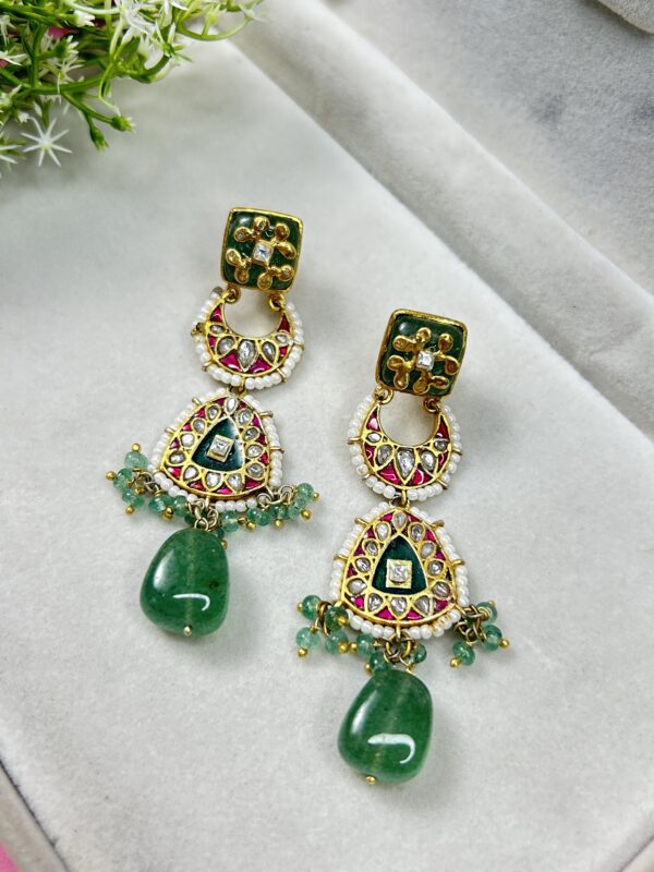 The earrings are displayed on a jewelry stand, which helps to showcase their design and size. The image is well-lit, allowing for a clear view of the details. Unique Fusion Earrings