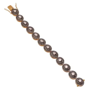The image shows an ornate bracelet featuring multiple oval-cut Polki diamonds, each encircled by smaller sparkling stones and set in a detailed metal frame. The bracelet has a traditional Indian aesthetic. Pave Diamond Gemstone Bangle